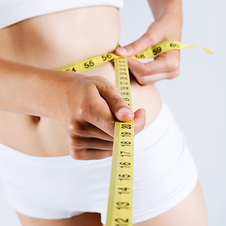 Mujer midiendo su cintura post tratamiento de HIFU corporal, Cavitación, Radiofrecuencia corporal y drenaje corporal en Klauclinic